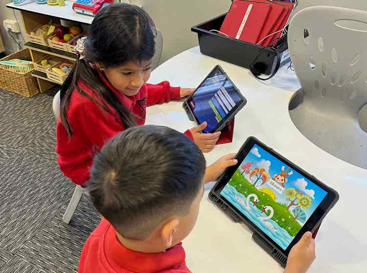 Two students working with iPads